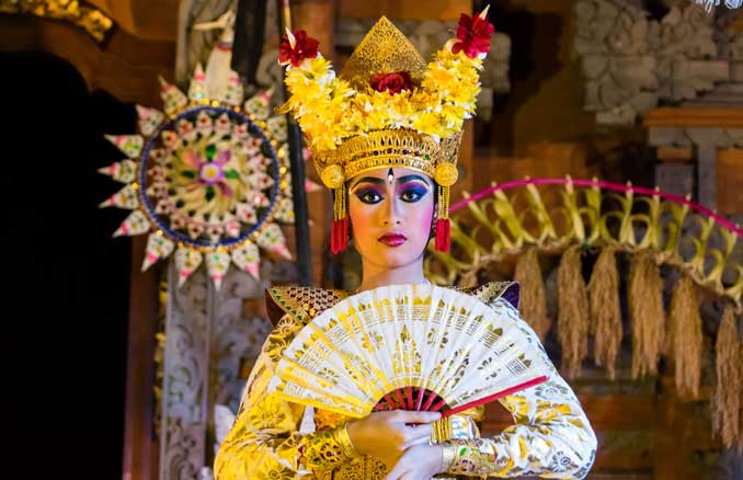 Legong dancer posing with fan.