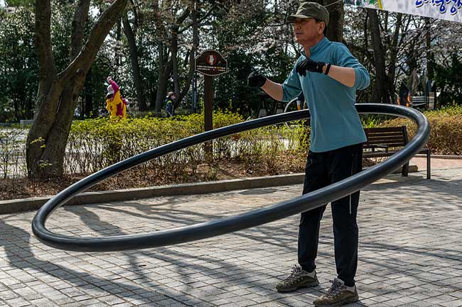 Man hula-hooping in the park.