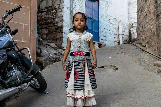 Little girl standing in alley.