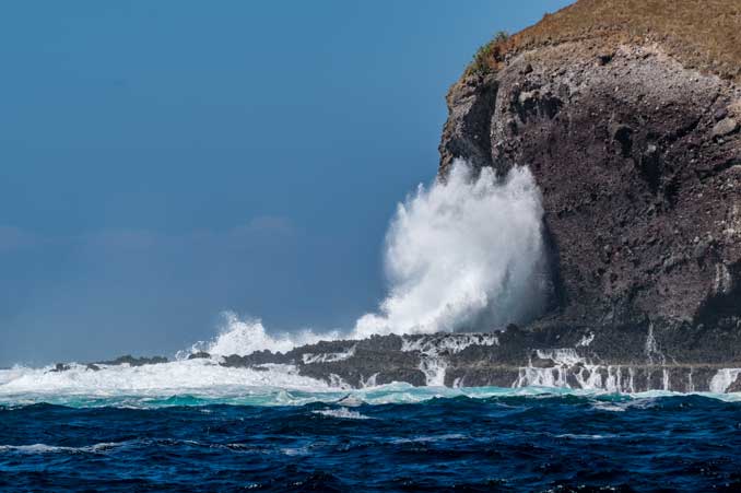 Waves crashing into the side of an island in Komodo National Park.