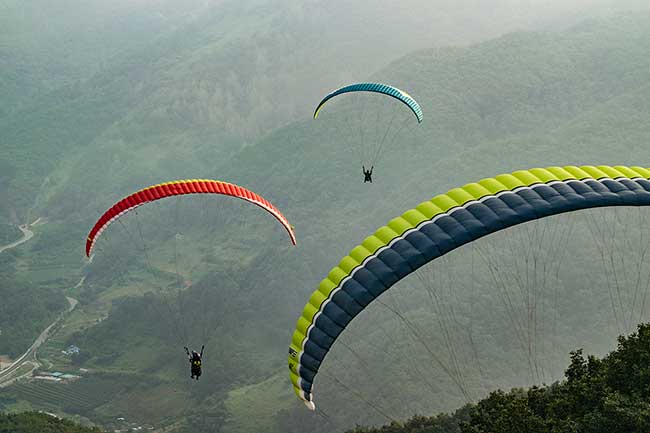 Three paragliders taking off.