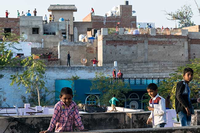 Kids on rooftop during kite festival.