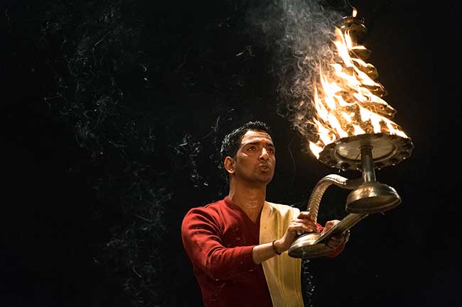 Priest holding candlabra.