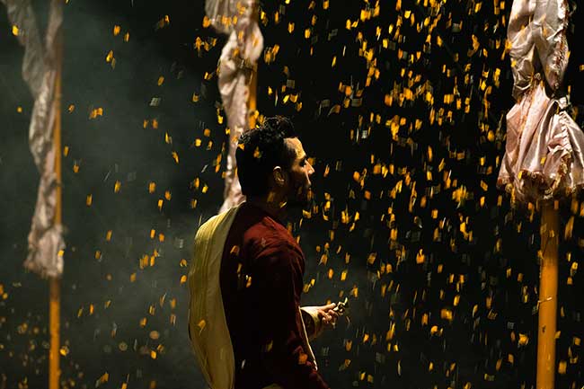 Yellow flower petals falling around priest.