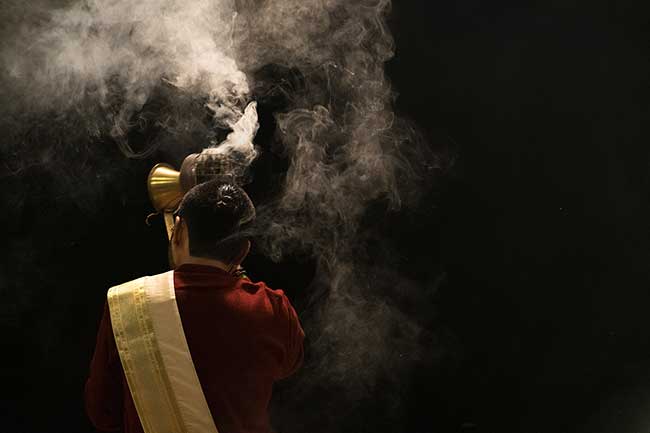 Priest facing away from camera.